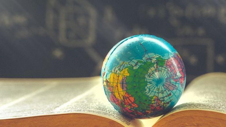 A small globe sitting on top of a book